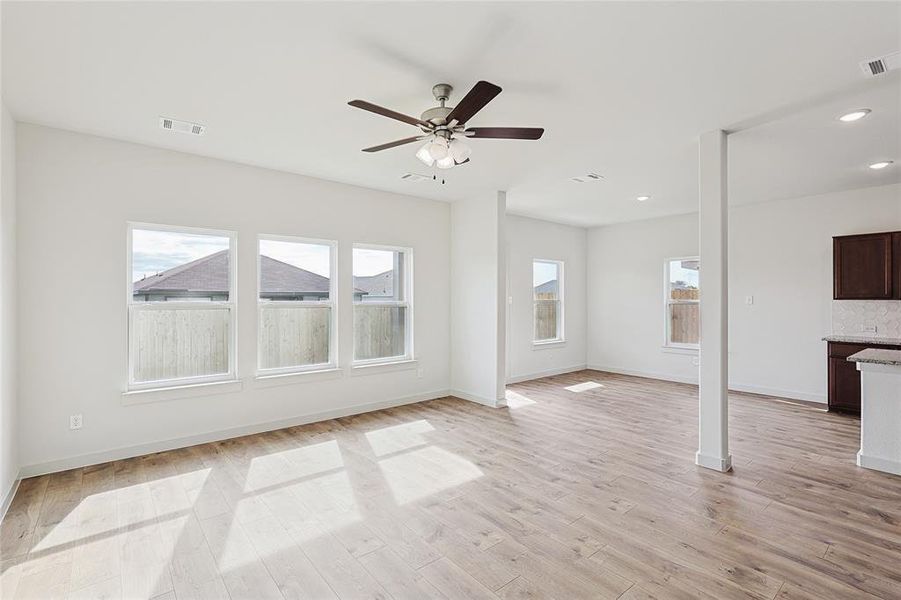 Unfurnished living room with ceiling fan and light hardwood / wood-style floors