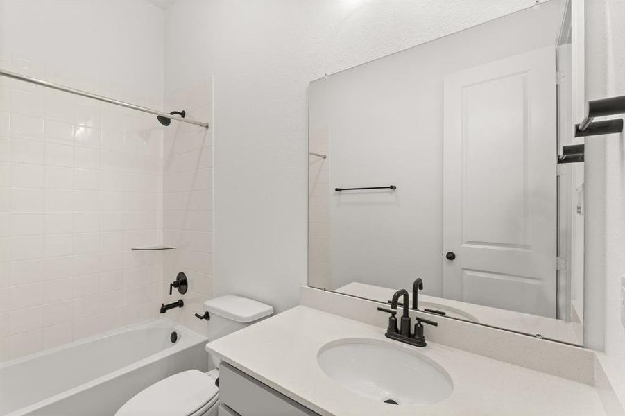 The secondary bath features tile flooring, white cabinetry and light countertops and a shower/tub combo. Perfect for accommodating any visiting family and friends.