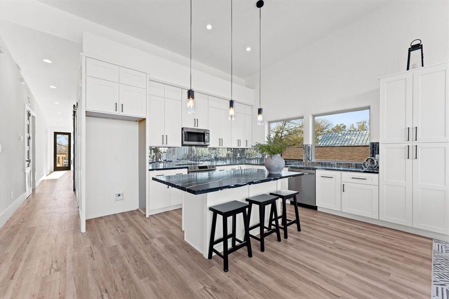 The kitchen is a true showstopper, featuring an 8-foot island, sleek modern finishes, and ample cabinet space