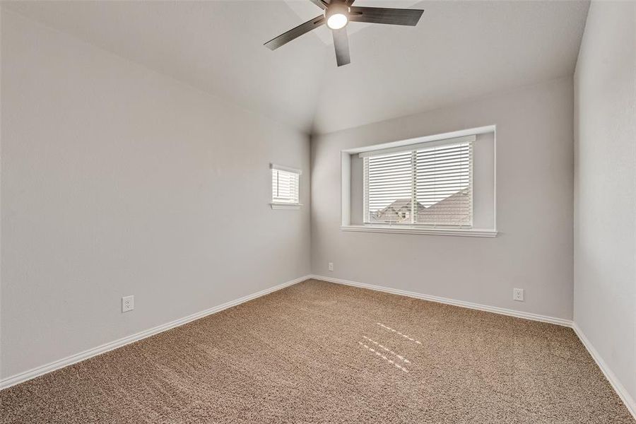 Spare room with carpet flooring, vaulted ceiling, and ceiling fan Spare room with carpet flooring, vaulted ceiling, and ceiling fan