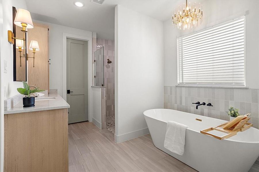 Bathroom with vanity, tile walls, independent shower and bath, and a chandelier