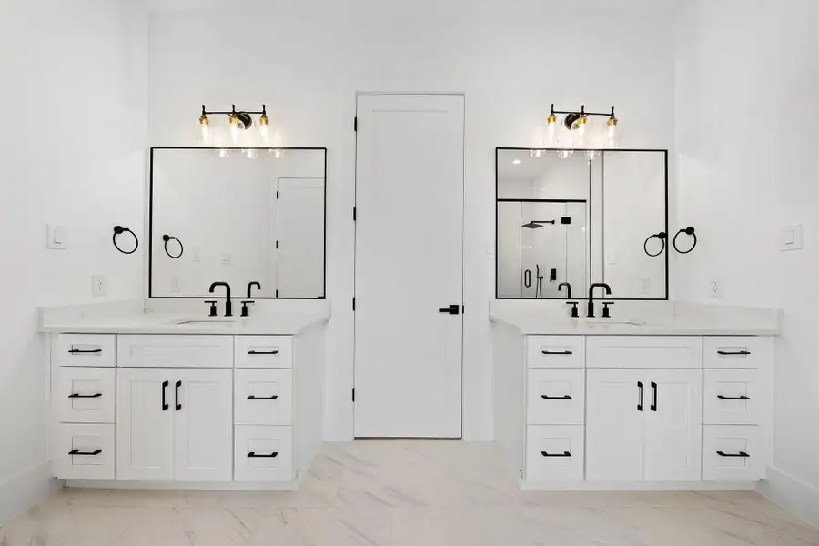 Dual vanities with quartz counters, designer fixtures, and black matte hardware. (Photos are of a previously completed home. Finishes are subject to change.) Dual vanities with quartz counters, designer fixtures, and black matte hardware. (Photos are of a previously completed home. Finishes are subject to change.)