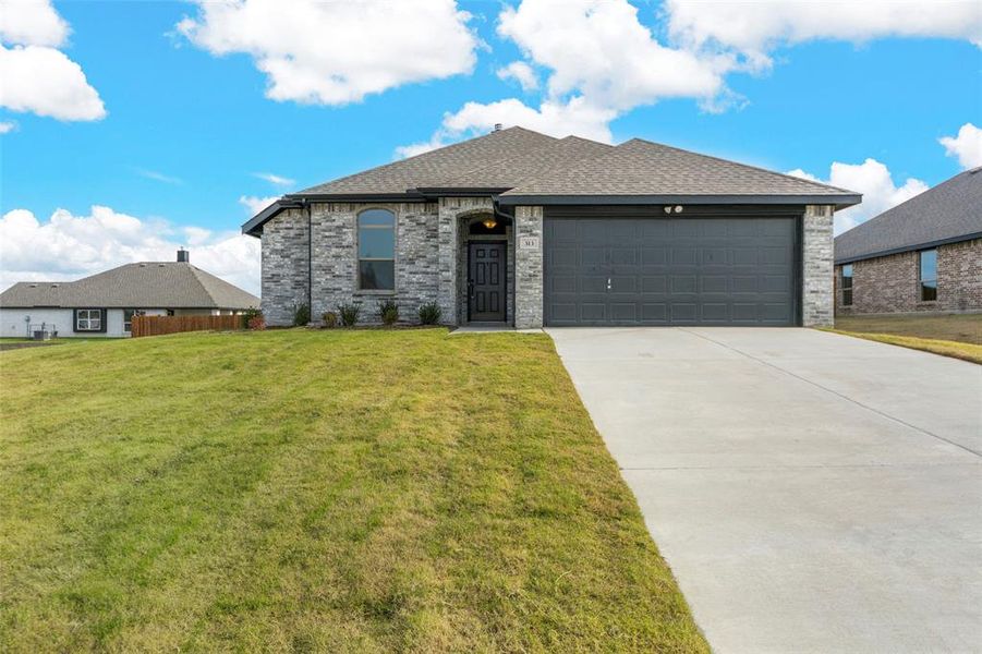 View of front of house featuring a garage and a front lawn