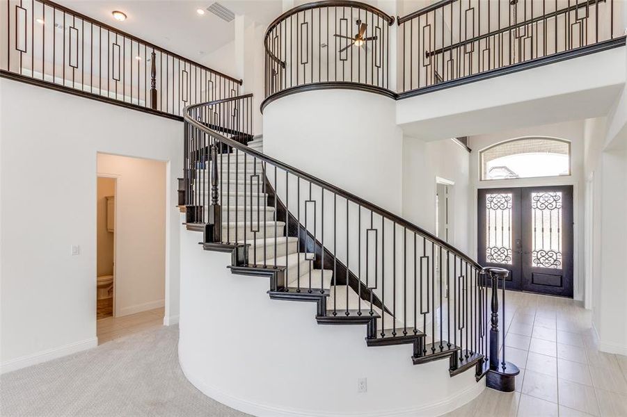 Curved staircase with modern iron railing really makes a statement.