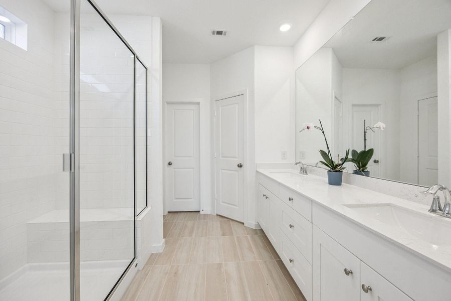 Primary Bedroom with large walk in shower and bench. Dual sinks with extra countertop space to easily get ready.