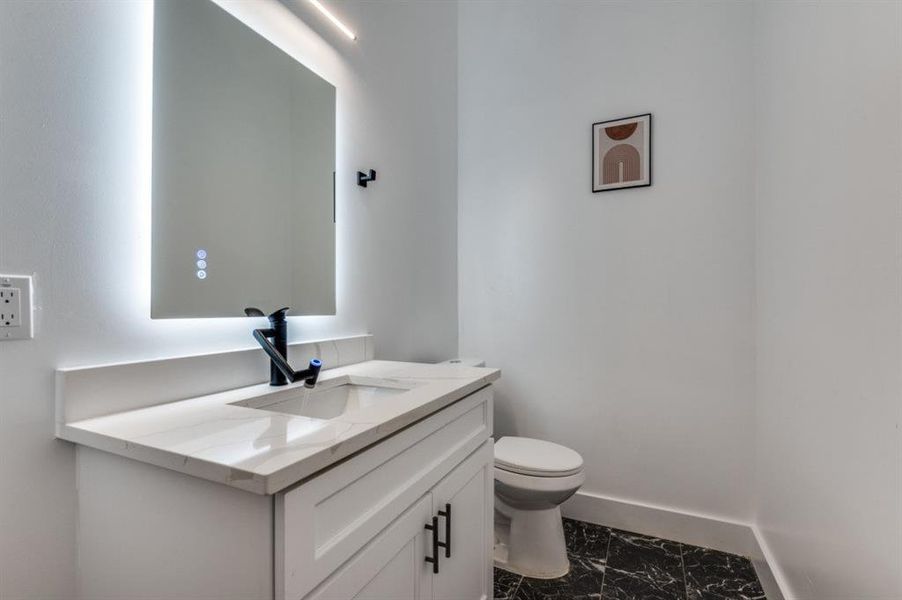 Well-appointed half bath featuring upscale tile work and illuminated anti-fog mirrors for added convenience and style. Well-appointed half bath featuring upscale tile work and illuminated anti-fog mirrors for added convenience and style.