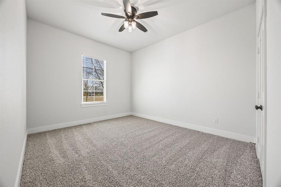 Carpeted spare room with baseboards and ceiling fan Carpeted spare room with baseboards and ceiling fan