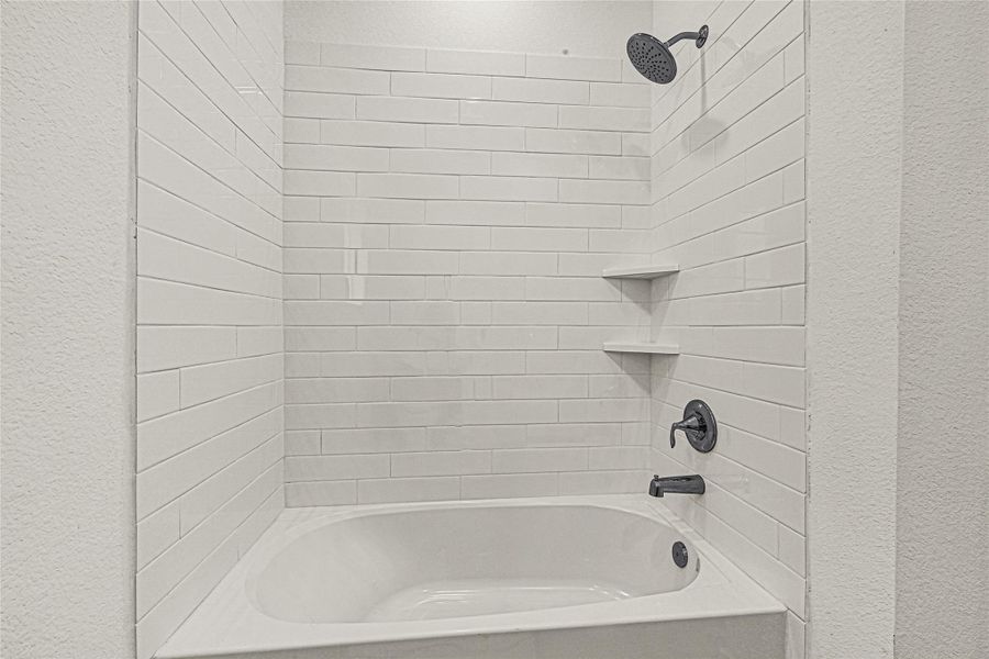 Modern bathroom with a clean, white subway-tile shower and tub combination. It features dark fixtures and built-in corner shelves, creating a sleek and functional design. Modern bathroom with a clean, white subway-tile shower and tub combination. It features dark fixtures and built-in corner shelves, creating a sleek and functional design.