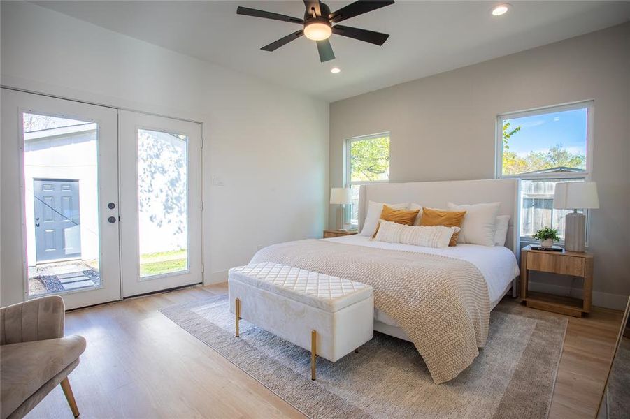 Bedroom with access to exterior, ceiling fan, light hardwood / wood-style flooring, and french doors