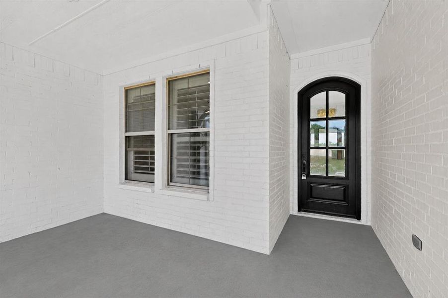 Arch-top entry door with glass panels and a black finish Arch-top entry door with glass panels and a black finish