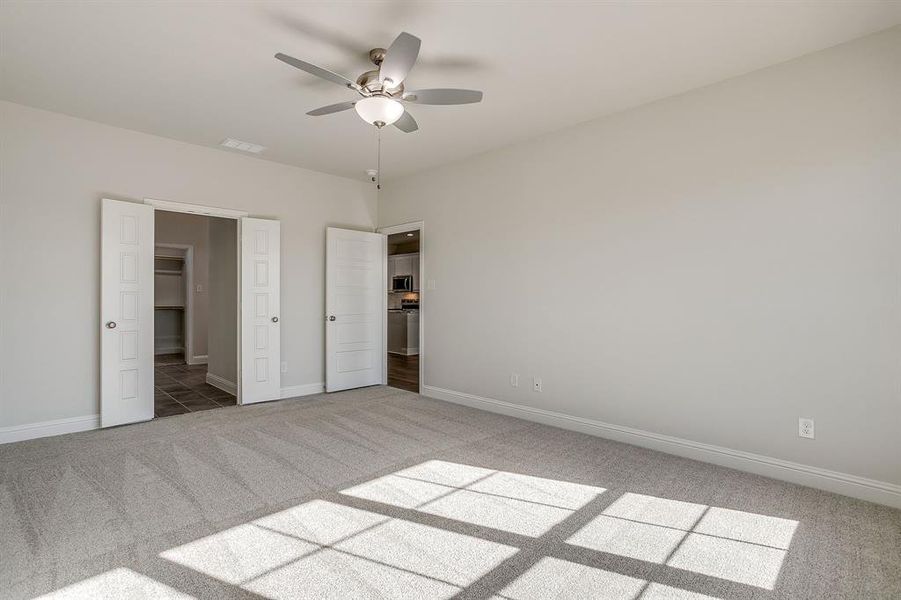 Unfurnished bedroom with light carpet and a ceiling fan