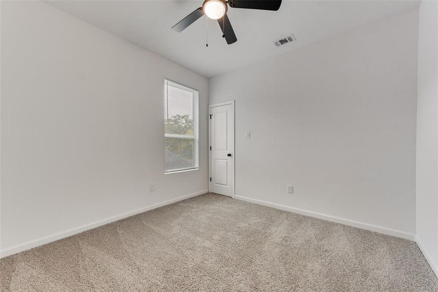 Carpeted empty room with ceiling fan