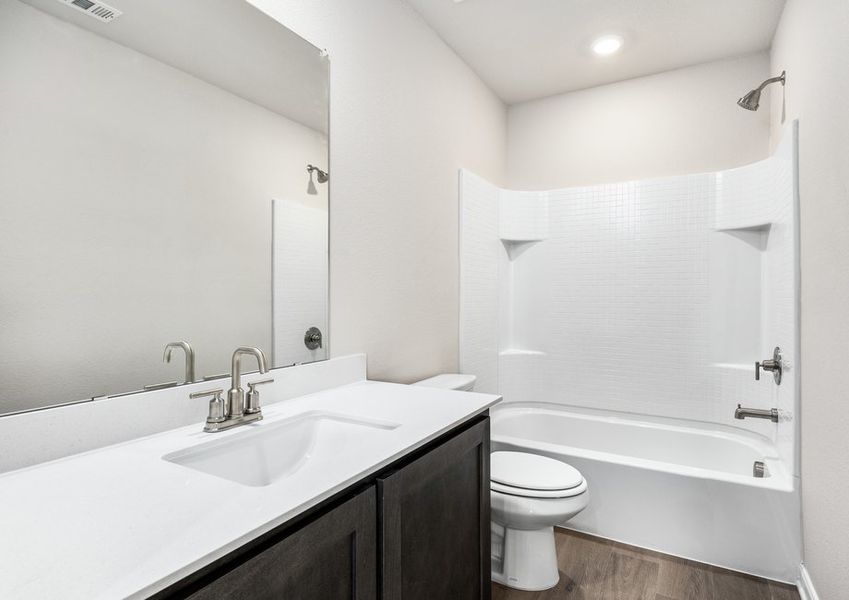The secondary bathroom has a sprawling vanity and a shower-tub combo. The secondary bathroom has a sprawling vanity and a shower-tub combo.