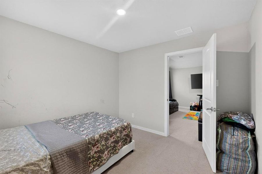 Bedroom featuring light carpet and baseboards Bedroom featuring light carpet and baseboards