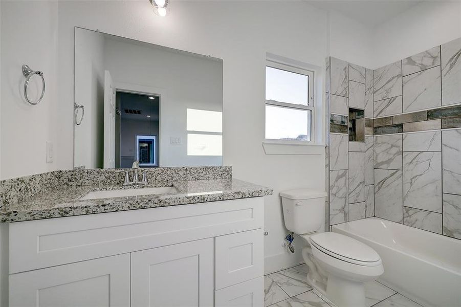 Secondary bathroom offers ample storage cabinetry and tub/shower combination