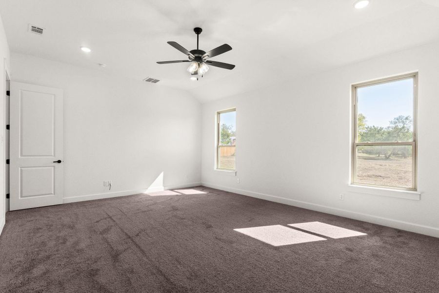 Empty room with dark carpet, recessed lighting, vaulted ceiling, and ceiling fan