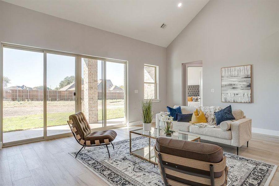 Living area featuring high vaulted ceiling and light wood-type flooring