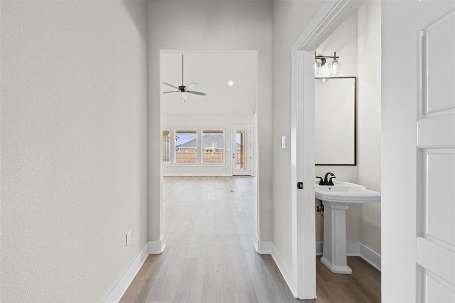 Corridor with light wood-style floors and baseboards