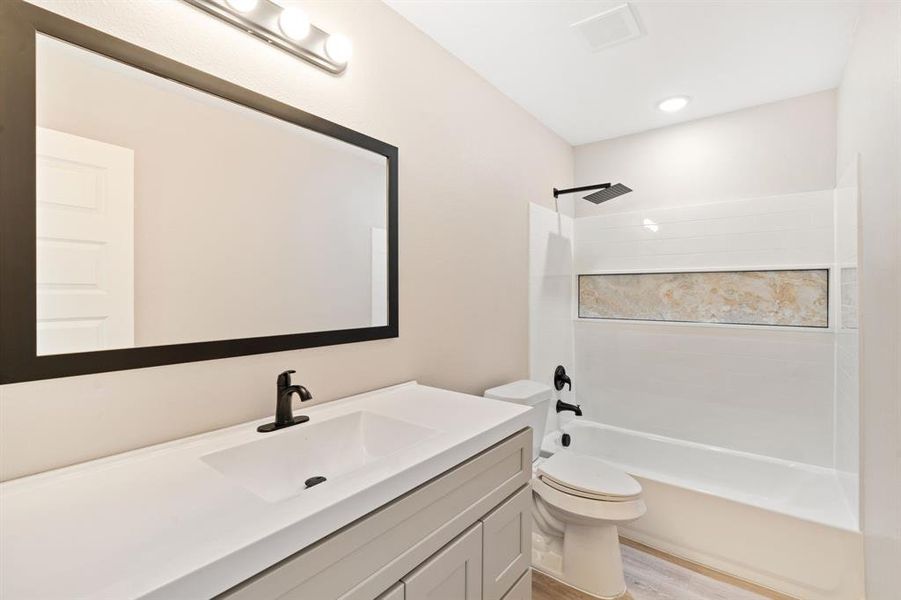 Full bathroom featuring washtub / shower combination, vanity, and light wood finished floors