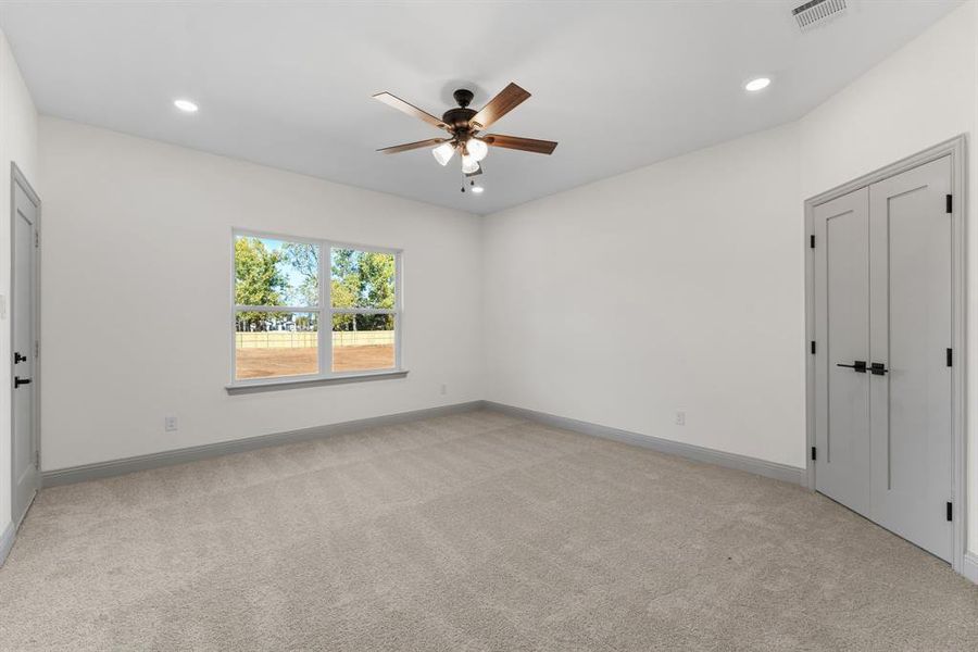 Unfurnished bedroom featuring light carpet, a ceiling fan, recessed lighting, and a closet