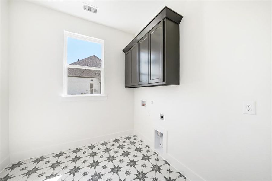 Washroom featuring cabinet space, electric dryer hookup, hookup for a washing machine, hookup for a gas dryer, and light floors