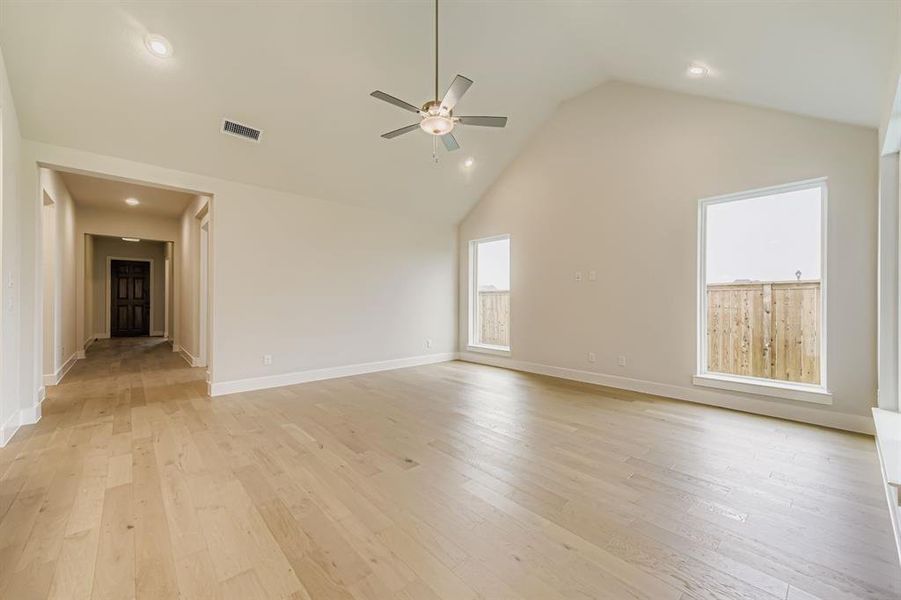 Spare room featuring light wood-style flooring, high vaulted ceiling, ceiling fan, and recessed lighting