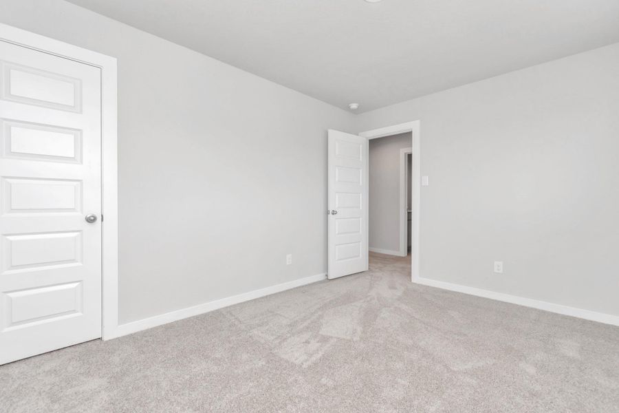 generously sized secondary bedrooms, showcasing 5-panel doors with modern hardware, large windows adorned with privacy blinds, and spacious closets boasting sleek and contemporary finishes. Sample photo of completed home with similar floor plan. Actual colors and selections may vary.