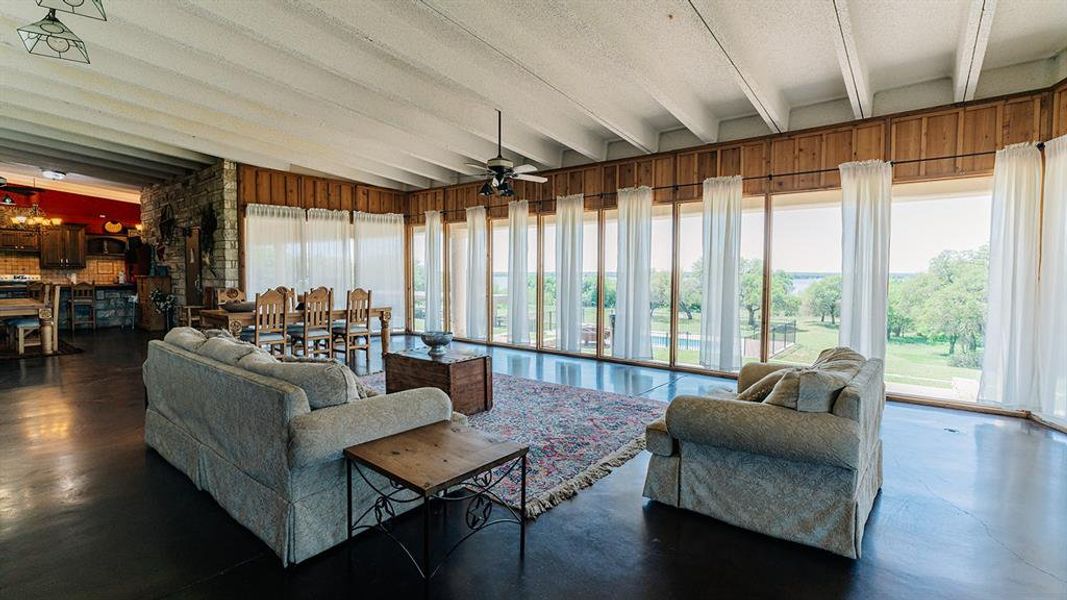 Living area with a ceiling fan and beam ceiling