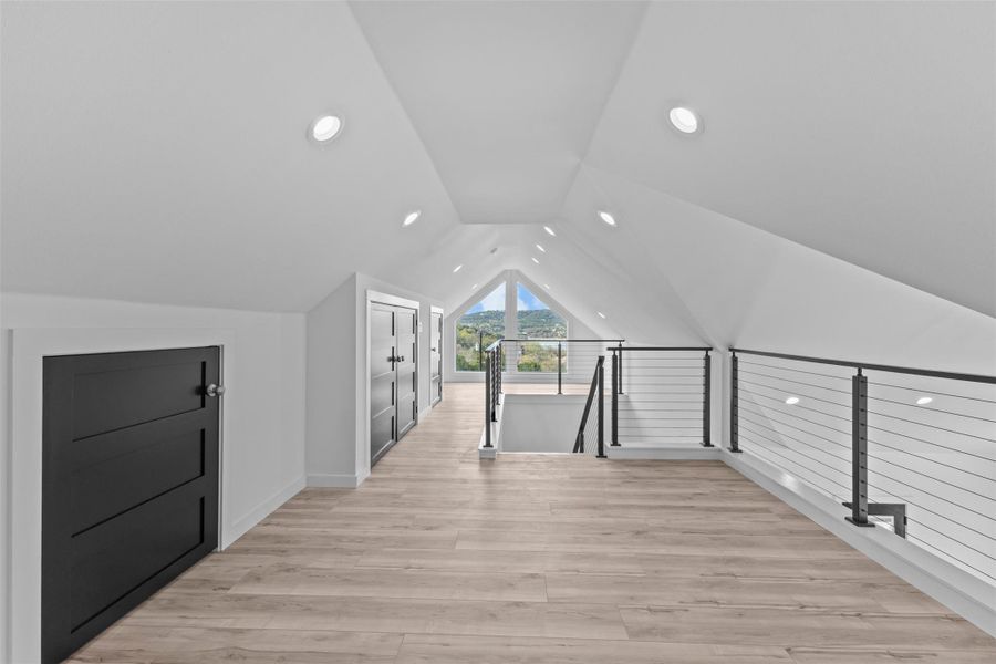 Additional living space with light wood-type flooring and baseboards