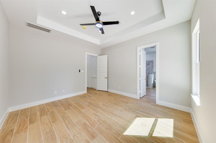 The master bedroom offers a luxurious view that opens up to a beautifully designed bathroom. With its 10-foot tray ceilings and sleek modern recessed lighting, the space exudes elegance and sophistication.