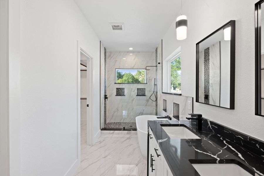 Primary Bathroom features a walk-in shower, double vanity and soaking tub.