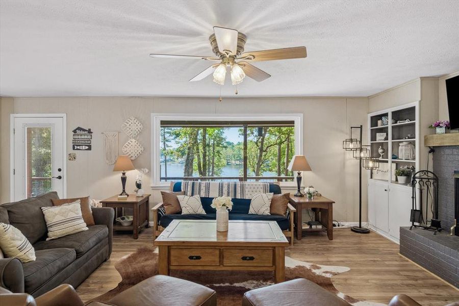 Expansive living area featuring a large picture window, water scenery, and built-in shelving