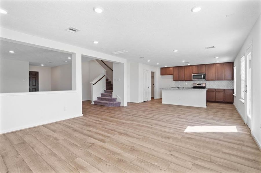 Another gorgeous view of the Great Room looking towards the kitchen and staircase leading to the 2nd floor.