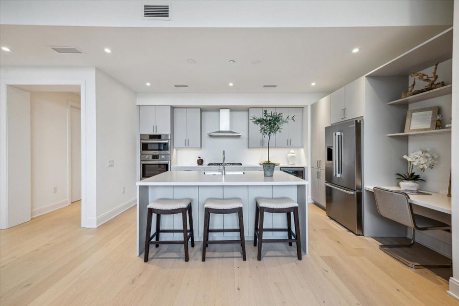 Kitchen is completed with built-in home office area with quartz desk and adjustable shelving.