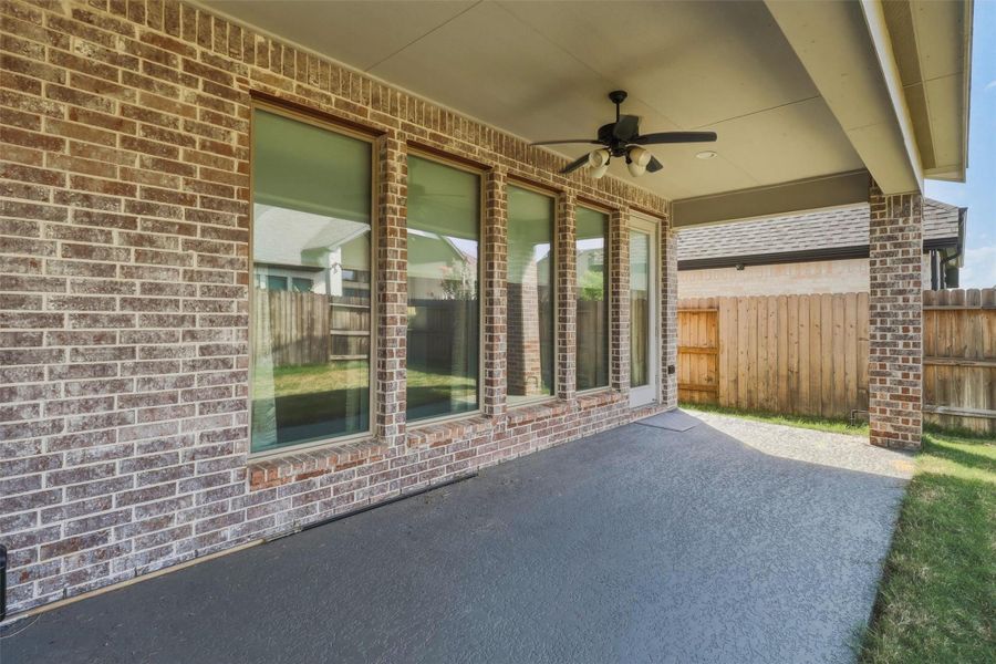 Enjoy shaded outdoor living beneath the spacious covered patio, complete with a ceiling fan for added comfort. Multiple rear windows provide abundant natural light indoors while maintaining seamless access to the backyard.