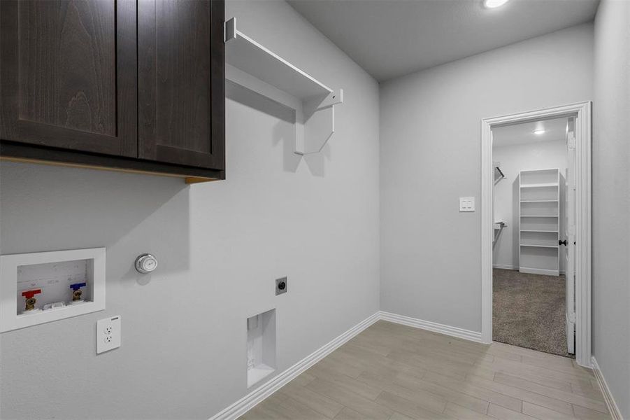 Laundry area featuring cabinets, hookup for a washing machine, light colored carpet, and hookup for an electric dryer