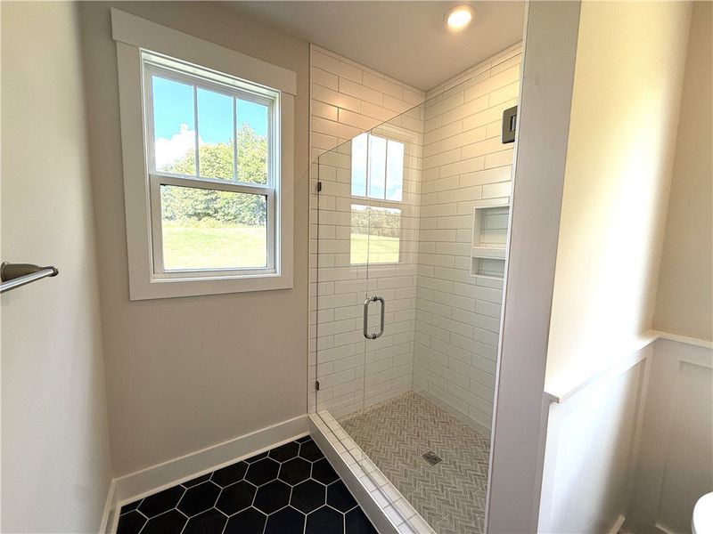 A window-lit shower with clean tile work and frame A window-lit shower with clean tile work and frame
