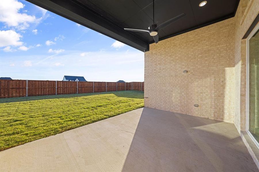 Fenced backyard with a patio and ceiling fan Fenced backyard with a patio and ceiling fan