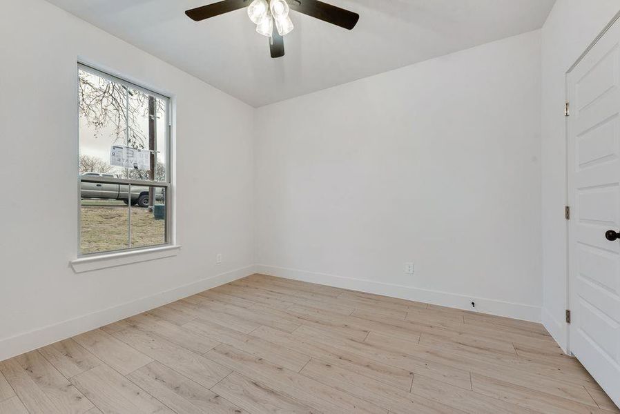 Empty room with light wood-style flooring and a ceiling fan