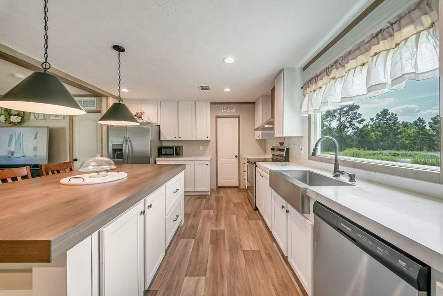 Love the views from the kitchen window. Notice the stainless steel farmhouse apron sink.