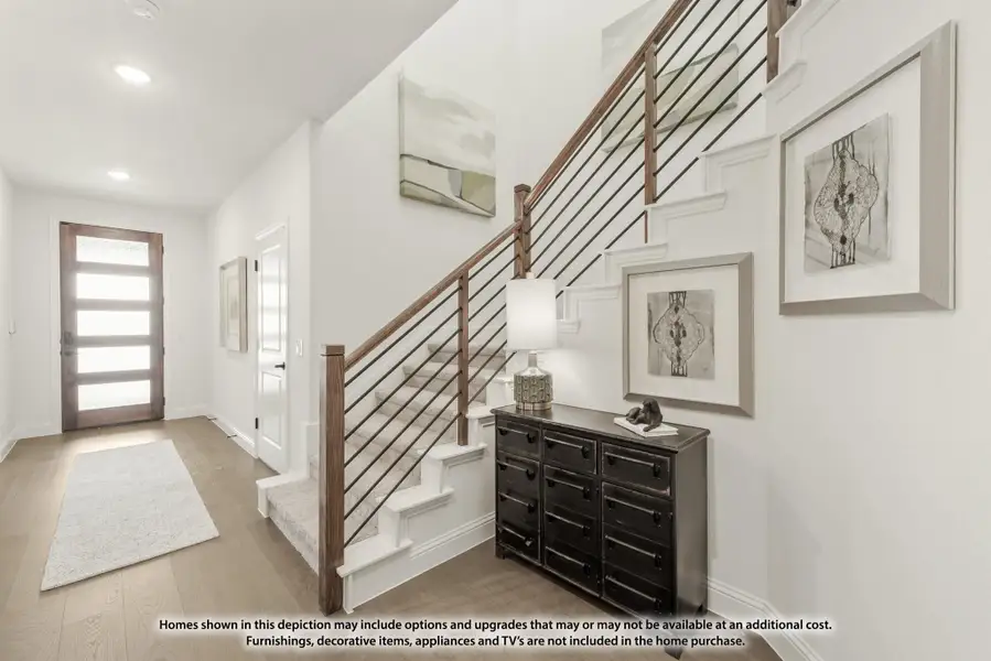 Foyer with staircase featuring wood and metal railing, hardwood floors, and modern front door with glass panels Foyer with staircase featuring wood and metal railing, hardwood floors, and modern front door with glass panels