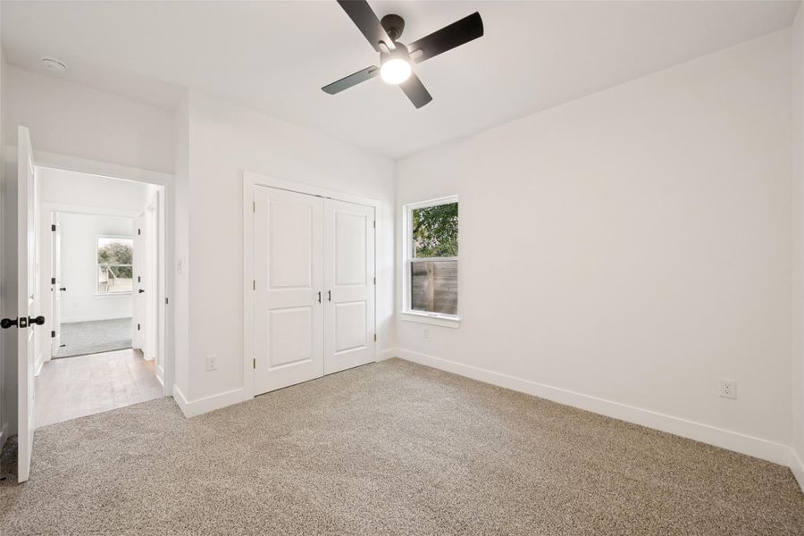 A well-lit room offers comfort with plush carpeting and a modern ceiling fan. A well-lit room offers comfort with plush carpeting and a modern ceiling fan.