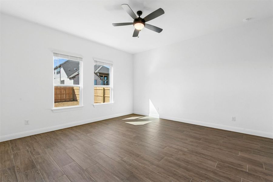 Unfurnished room featuring dark wood-style floors and a ceiling fan
