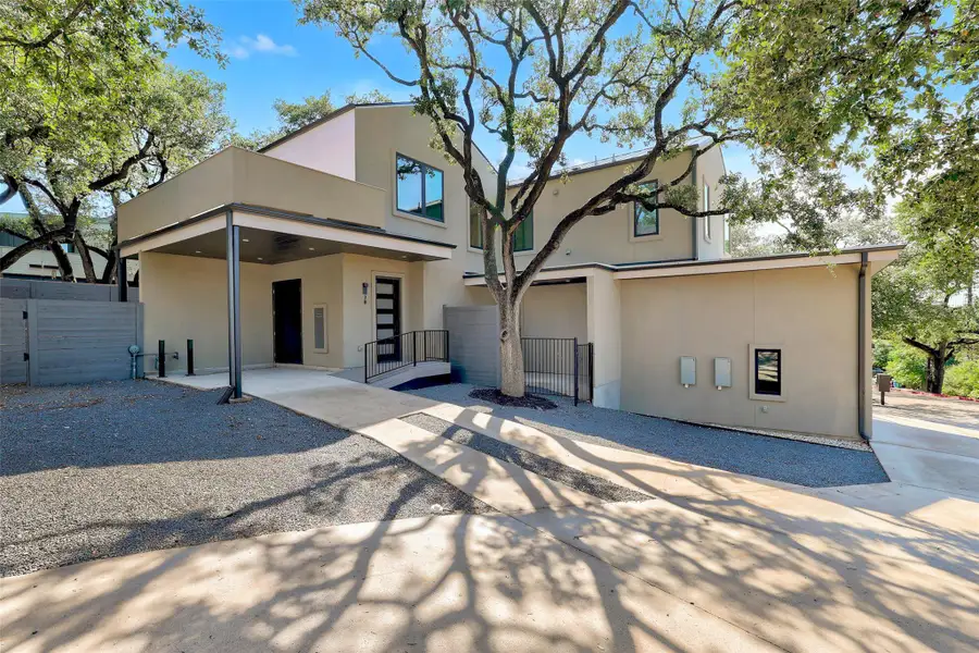 Back of house with a gate and stucco siding