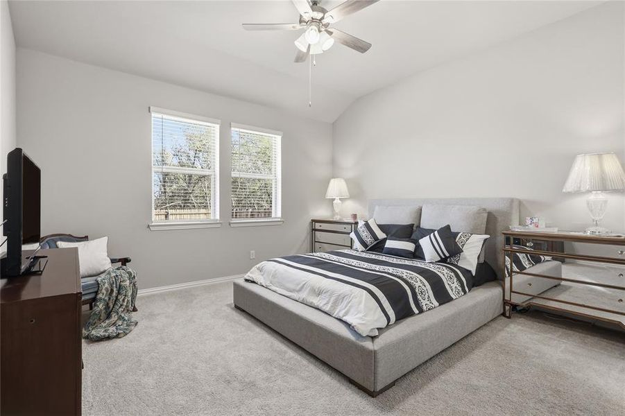 Spacious room featuring vaulted ceilings, light gray wall paint, and light gray carpet flooring