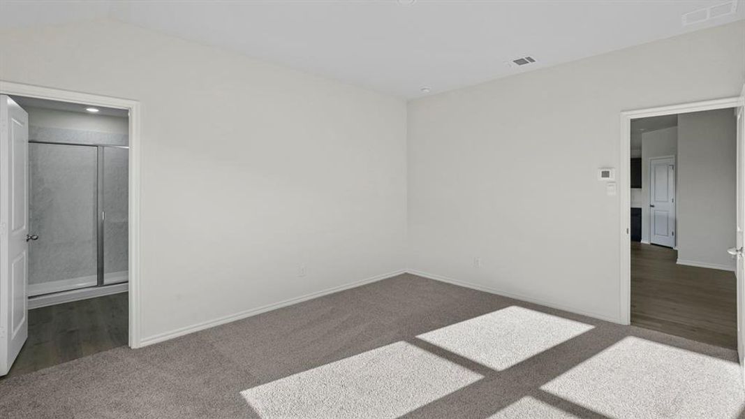 Unfurnished bedroom featuring dark carpet and ensuite bathroom