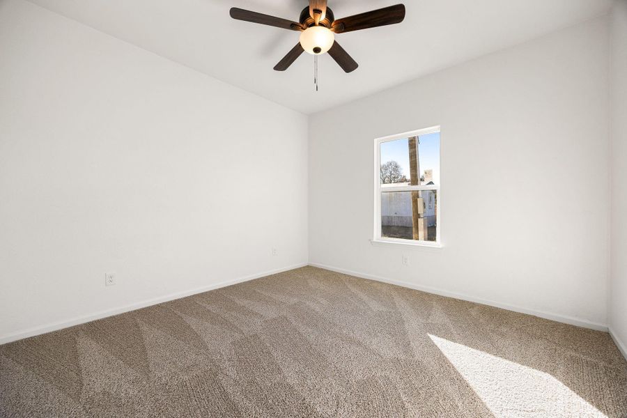 Bright and spacious bedroom with a ceiling fan and plush carpet, ideal for relaxation. Bright and spacious bedroom with a ceiling fan and plush carpet, ideal for relaxation.