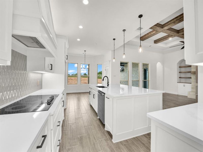 Kitchen with beamed ceiling, white cabinets, coffered ceiling, wood tiled floors, and decorative light fixtures