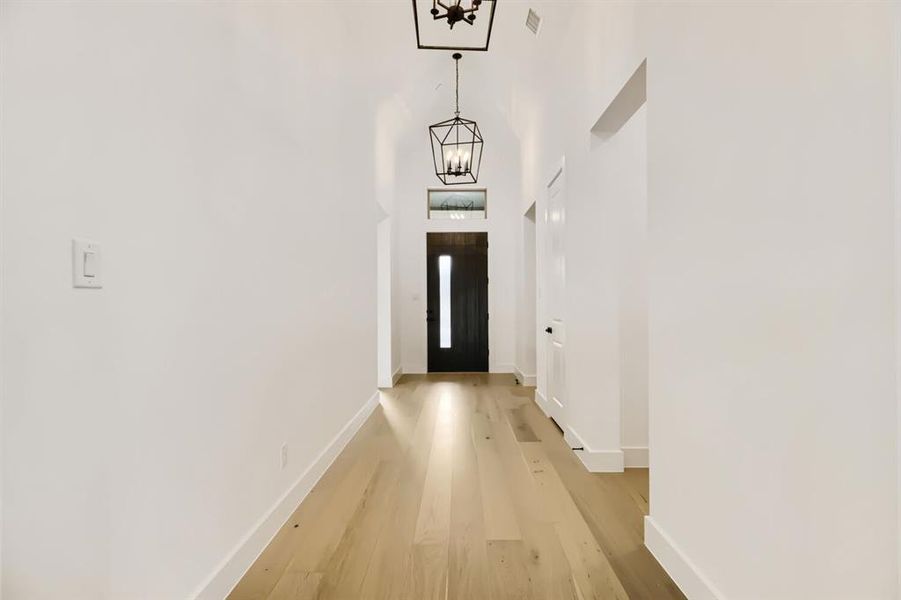 Entryway featuring a chandelier, wood finished floors, and a high ceiling