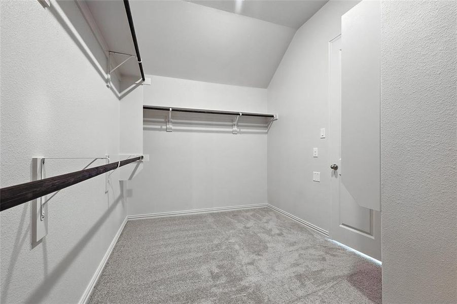 Walk in closet with carpet floors and vaulted ceiling Walk in closet with carpet floors and vaulted ceiling